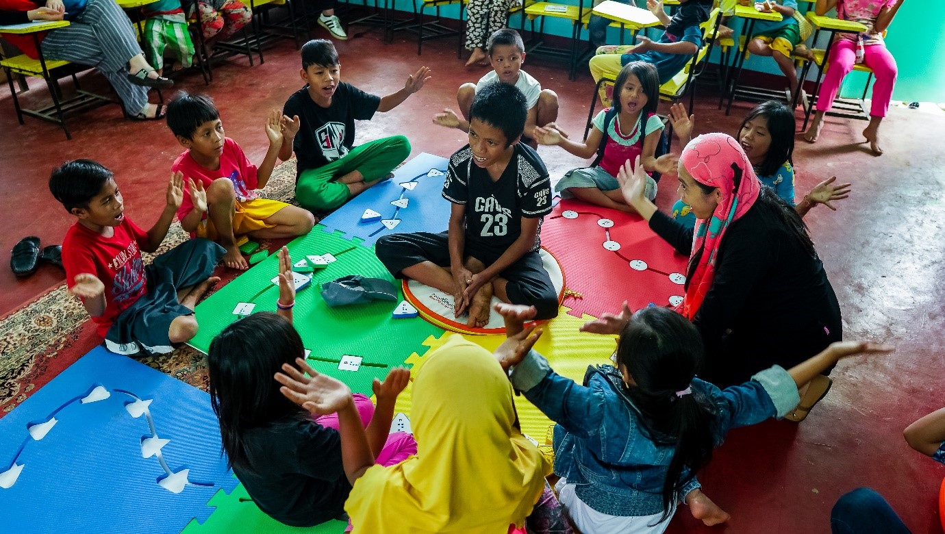 Photo: Children participating in a Reach & Match activity focussed on building social interactions amongst classmates with special needs.